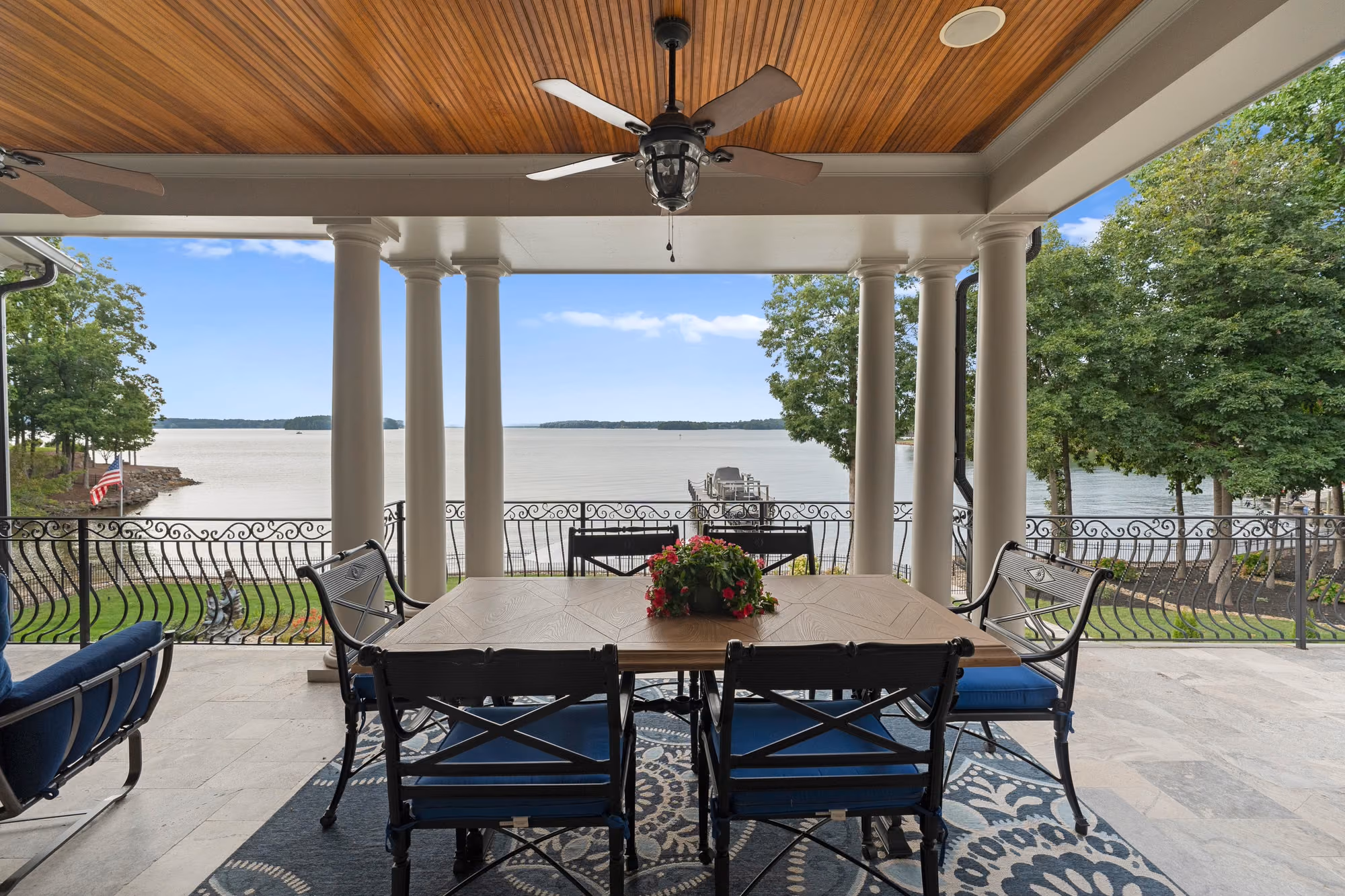 A covered porch set for dinner, looking straight out at open water.