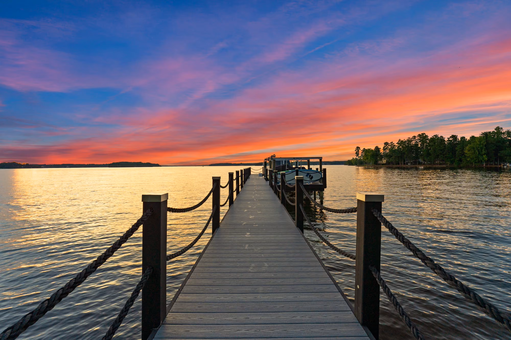 A private dock running out into Lake Norman at sunset.