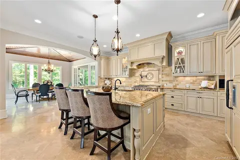 Breakfast bar makes this a perfect spot to hang out.  Lighted display cabinets, pot filler over the stove and gorgeous granite countertops.  Travertine floors.