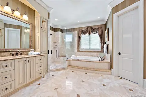 Large master bathroom with walk in shower, jetted tub and dual vanities.  Plenty of storage areas and lighted display at top of cabinets. Heated tile floors.