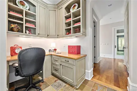 Main floor office nook/computer niche has stone flooring and built ins.
