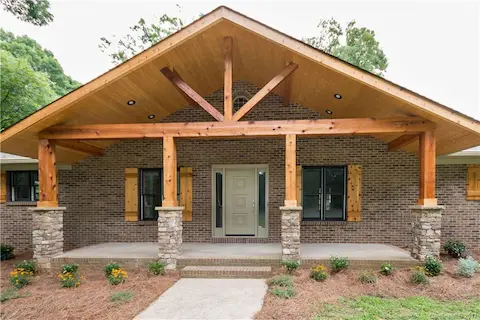 The warmth of the wood adds to the beauty of this large front porch. A wonderful place to spend an afternoon relaxing and enjoying the quiet surroundings.