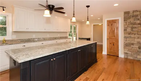This view of the kitchen is looking back towards to the front hallway.  A half bath and coat closet are in the foreground as well.