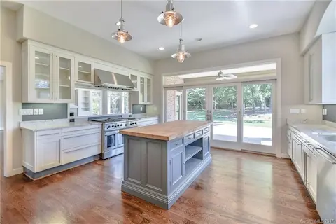 Upgraded kitchen with stainless steel appliances, granite, custom island & lighting & hardwood floors