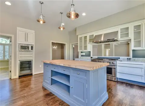 Upgraded kitchen with stainless steel appliances, granite, custom island & lighting & hardwood floors