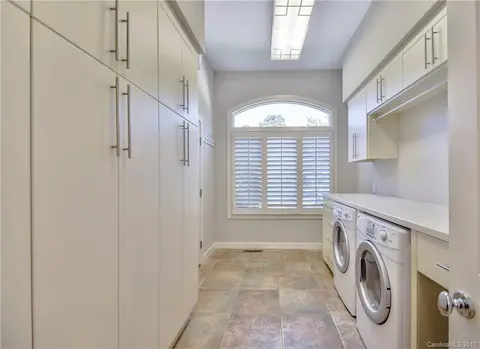 Large laundry room with custom cabinets for storage