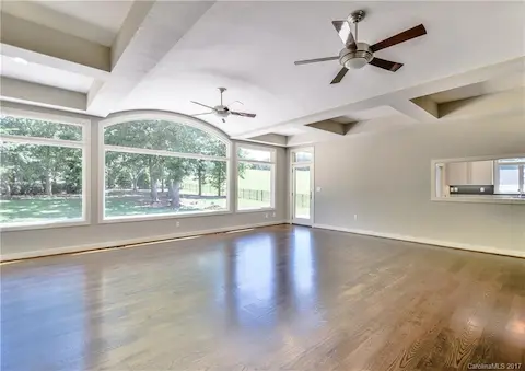 Great Room with built in shelving, gas fireplace, ceiling fans, hardwood floors & beautiful, expansive view of golf course