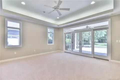 Master bedroom on main level with tray ceiling & ceiling fan