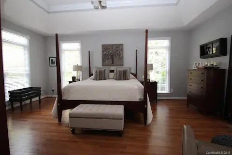 Large master bedroom with hardwood floors and ceiling fan.
