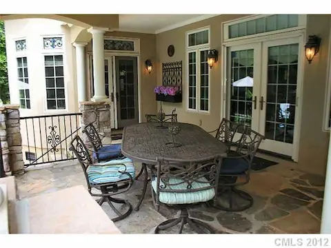 Porch - Covered patio with stone flooring and accent columns, beaded ceiling, & palm fan.