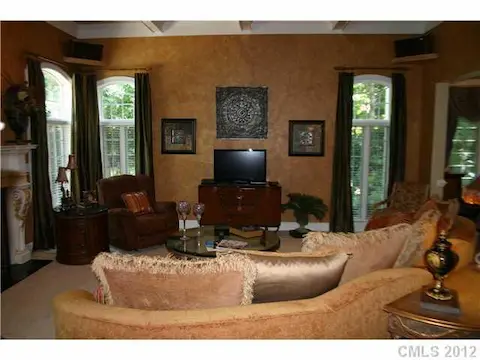 Great Room - Impressive and spacious, this sunken great room features a high, coffered ceiling, gas log fireplace with custom hand-painted mantel, surround sound throughout the first floor and beautiful arched windows.
