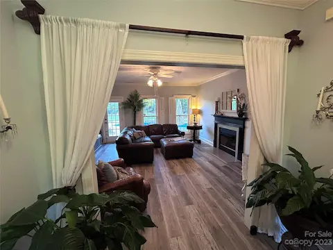 Sneak peek of the 16 x 17 family room from the foyer. Beautiful light slate blue wall color.  Crown molding throughout the home.  Arched ceilings in the dining room to the left and in the 3rd bedroom/office to the right.   Also to the right is located the 2nd bedroom and full hallway bath/powder room.