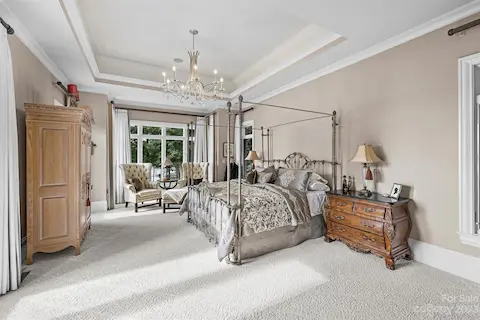 Primary Bedroom with tray ceiling and custom carpet
