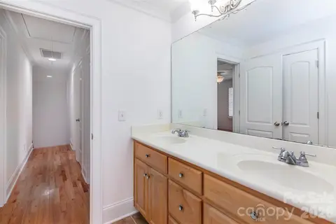 Second hardwood/iron stairs lead to upstairs hall and FBA (2 vanities, db door linen closet and separate door to tub/shower room with window)
