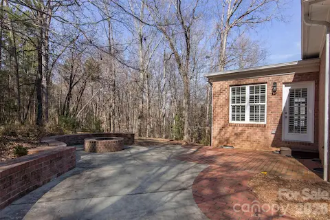 Enjoy friends and family gatherings around custom brick firepit - concrete/brick patio - door leads to sunroom/dining room and walkway extending down side of house to 29 ft deck!