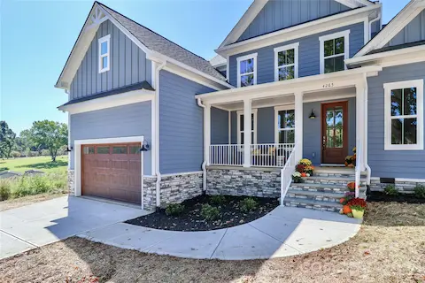 The spacious driveway, attached garage, and front walkway all add character and elegance to this custom-built home. The design elements work together to create curb appeal.