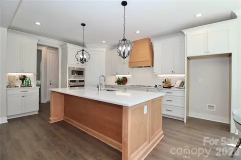 A gorgeous chef-inspired kitchen with Quartz countertops featuring a large center island. Ideal for gatherings and entertainment.