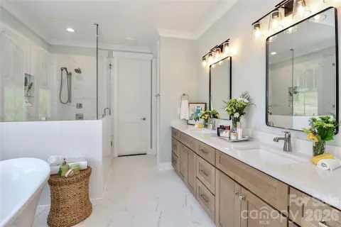 This bathroom offers a luxurious and relaxing experience. The design elements incorporate calming colors, natural materials, while highlighting features including a soaking tub, a rain shower, and shower seating.