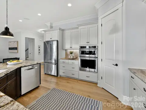 Entertain with ease in the beautifully designed kitchen complete with an oversized island, double ovens, abundant cabinetry, and an open-concept layout that flows throughout the home.