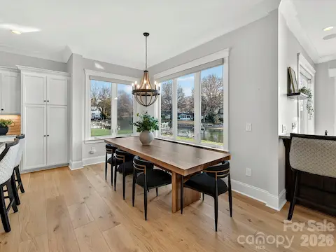 Bright dining area framed by expansive windows showcases beautiful waterfront views, creating the perfect setting for everyday meals and memorable gatherings.