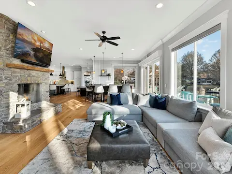 Bright and inviting Great Room offers panoramic Lake Norman views, abundant natural light, a cozy stone fireplace, and an open-concept design that flows effortlessly into the kitchen and dining areas.