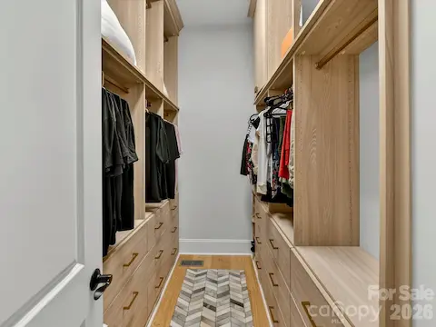 Spacious custom walk-in primary closet features built-in shelving, abundant hanging space, and extensive drawer storage for exceptional organization.