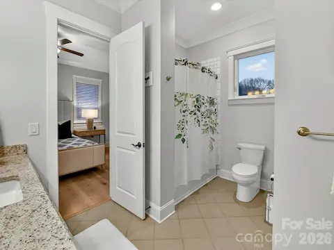 Well-appointed guest ensuite bath features a granite-topped vanity, generous storage, and stylish finishes for comfort and convenience.