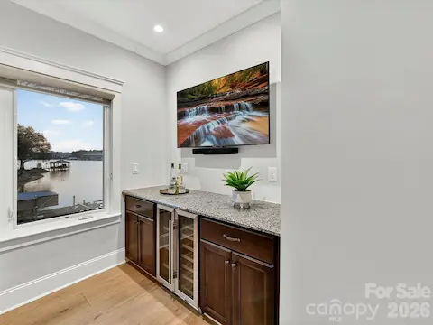 The second-floor wet bar features granite countertops, built-in beverage refrigerators, and a convenient serving area for effortless entertaining.