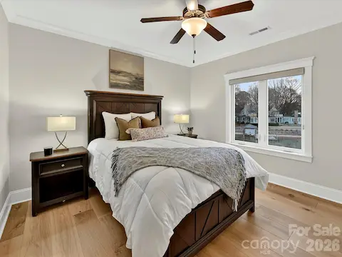Bedroom 4 offers a spacious layout with abundant natural light, ceiling fan, and peaceful water views for a comfortable guest or family retreat.