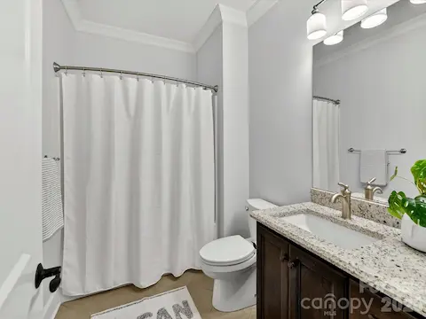 Well-appointed full bath features a granite-topped vanity, tile flooring, and a tub/shower combination, offering both style and everyday convenience.