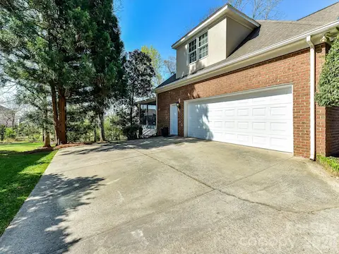 Spacious driveway leading to attached 2-car garage with separate entrance through a door