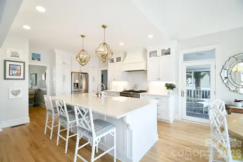 Gorgeous, updated Kitchen with white cabinets to the ceiling and quartz island with beautiful pendant lights