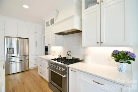 Beautiful tile backsplash, custom vent hood and 6 burner gas range