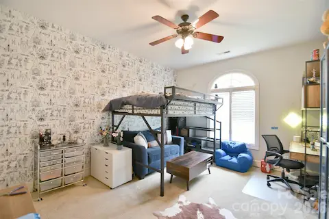 Large Bedroom #2 with tall ceilings and a large, arched window