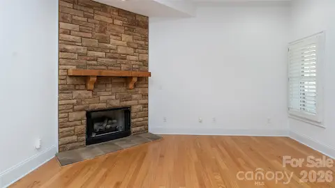 close up of stone to ceiling fp-ventless gas logs, natural wood mantel