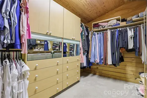 Walk-in closet with built-ins off changing area of primary bathroom.