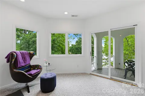 Primary suite sitting area leading to private balcony and water views.