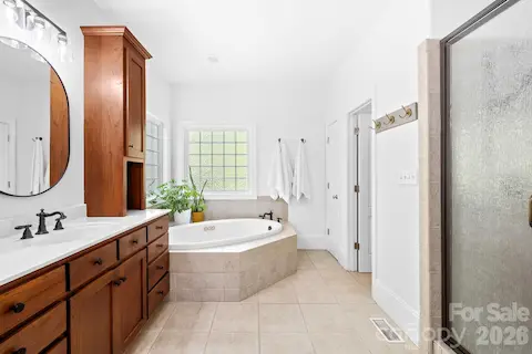 Primary bathroom has a walk-in shower, jacuzzi garden tub, linen closet and tiled flooring.