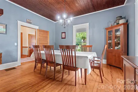 Spacious dining room open to the kitchen with wood bead board ceilings and fireplace.