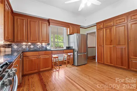 The classically updated kitchen offers high-quality wood cabinetry, granite countertops, and a design that honors the home’s history while supporting modern use.