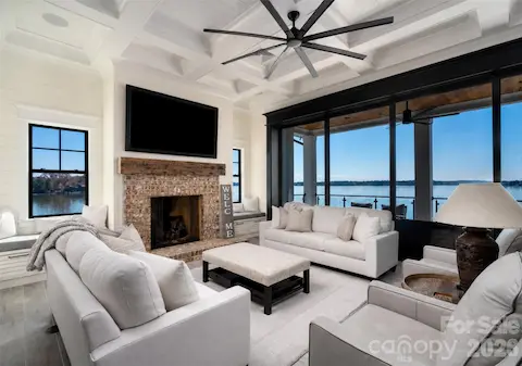 STUNNING UPPER LEVEL LIVING SPACE BOASTING A SPECTACULAR COFFERED CEILING, SHIPLAP DETAIL AND PERFECTLY FRAMED FLOOR TO CEILING STACKING DOORS TO INVITE THE LAKE BREEZE INTO THIS MAGNIFICENT OPEN-CONCEPT LIVING SPACE