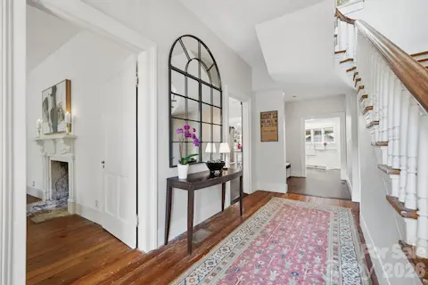 A wide foyer and traditional T-Shaped Vernacular Victorian Farmhouse opens to the original handcrafted staircase with winding switchback design.  Niche area set up as a drop station with coat hooks