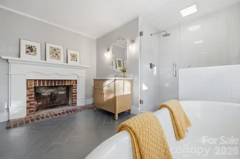 Primary bathroom also renovated, with tile floors, fireplace, soaking tub, tile and frameless glass shower with Hansgrohe raindance shower head and Kohler Malin Studio Vanity.