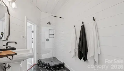Tile floors, tile and frameless glass shower, music and lighting and shiplap walls.