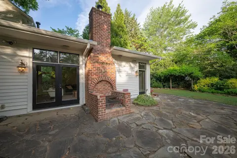 Built-in brick grill uses wood or charcoal.  Doors open to great room