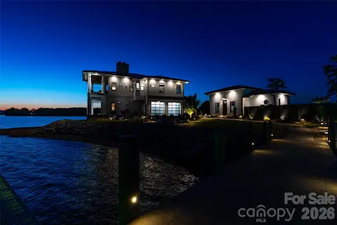 WHERE LUXURY MEETS THE LAST LIGHT OF DAY. TWO LEVELS OF SPACIOUS LIVING WITH EXQUISITE EXTERIOR TWILIGHT ILLUMINATION SHOWCASING THE SEAMLESS ARCHITECTURAL INTEGRATION, SITUATED ON A PRISTINE EDGE OF LAKE NORMAN