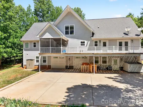 Massive concrete parking/entertaining area in rear of home