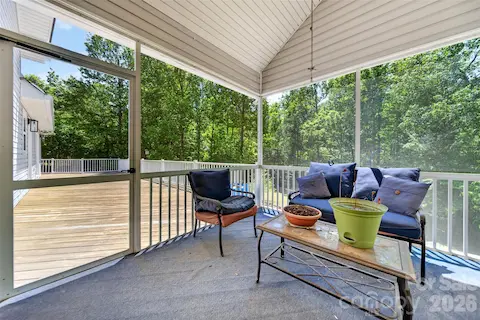 Porch enclosed by screens to provide protection from insects while allowing fresh air and natural light.