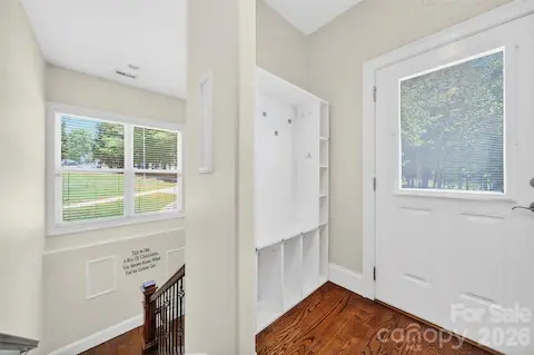 Side entry door with drop zone and wide hardwood steps down to the basement.