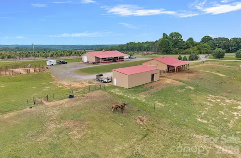 Two barns with 9 stalls and 3,184 sq ft workshop.